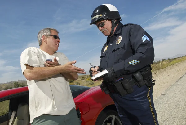 Дорожный полицейский выписывает штраф нарушителю — стоковое фото