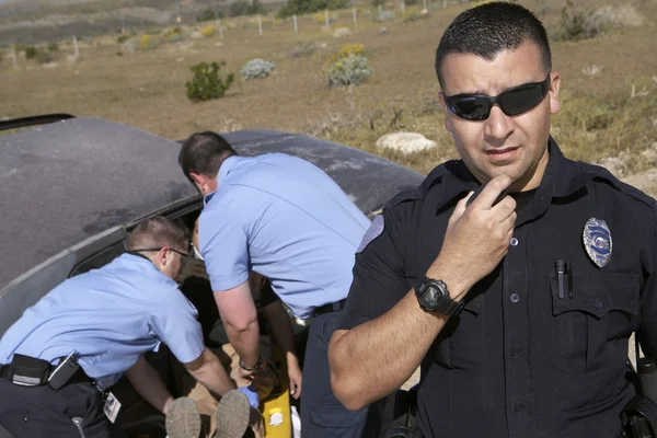 Офицер полиции с фельдшеров, спасая жертва аварии автомобиль — стоковое фото