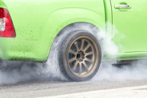 Гоночный автомобиль горит резина от своих шин в рамках подготовки к гонке — стоковое фото