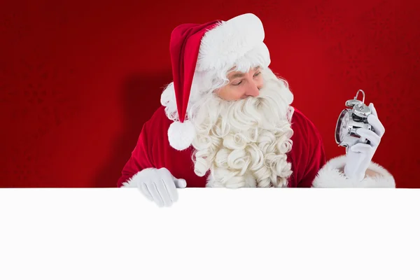 Счастливый Санта, держащий будильник и знак — стоковое фото