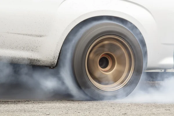 Гоночный автомобиль горит резина от его шины — стоковое фото